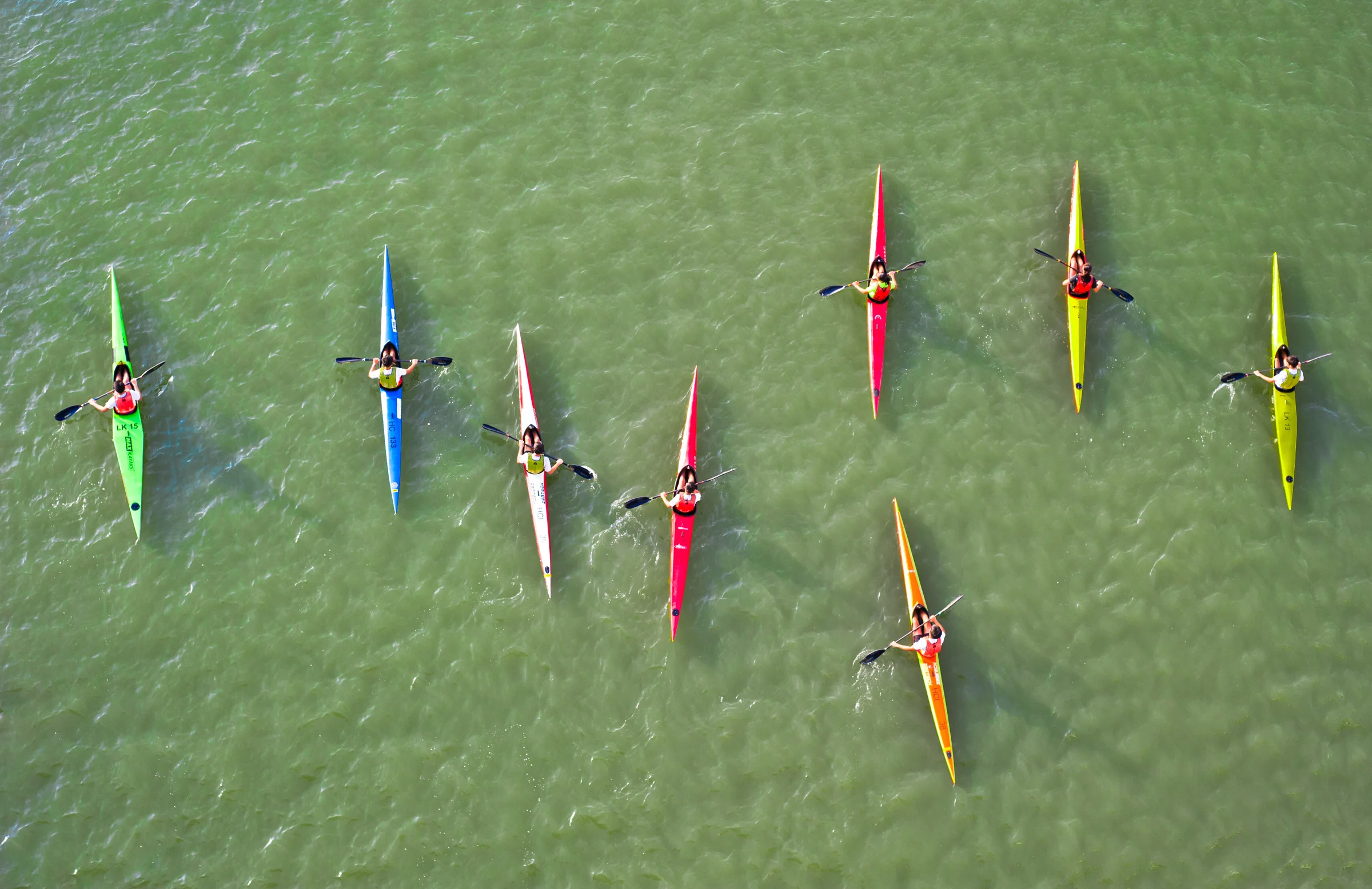Kayaks paddle through the algae bloom at the Marina Channel.