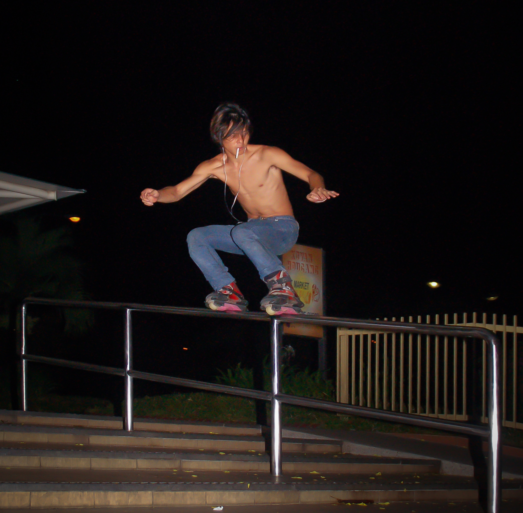 A skater grinds down a handrail while smoking at Hougang Central.