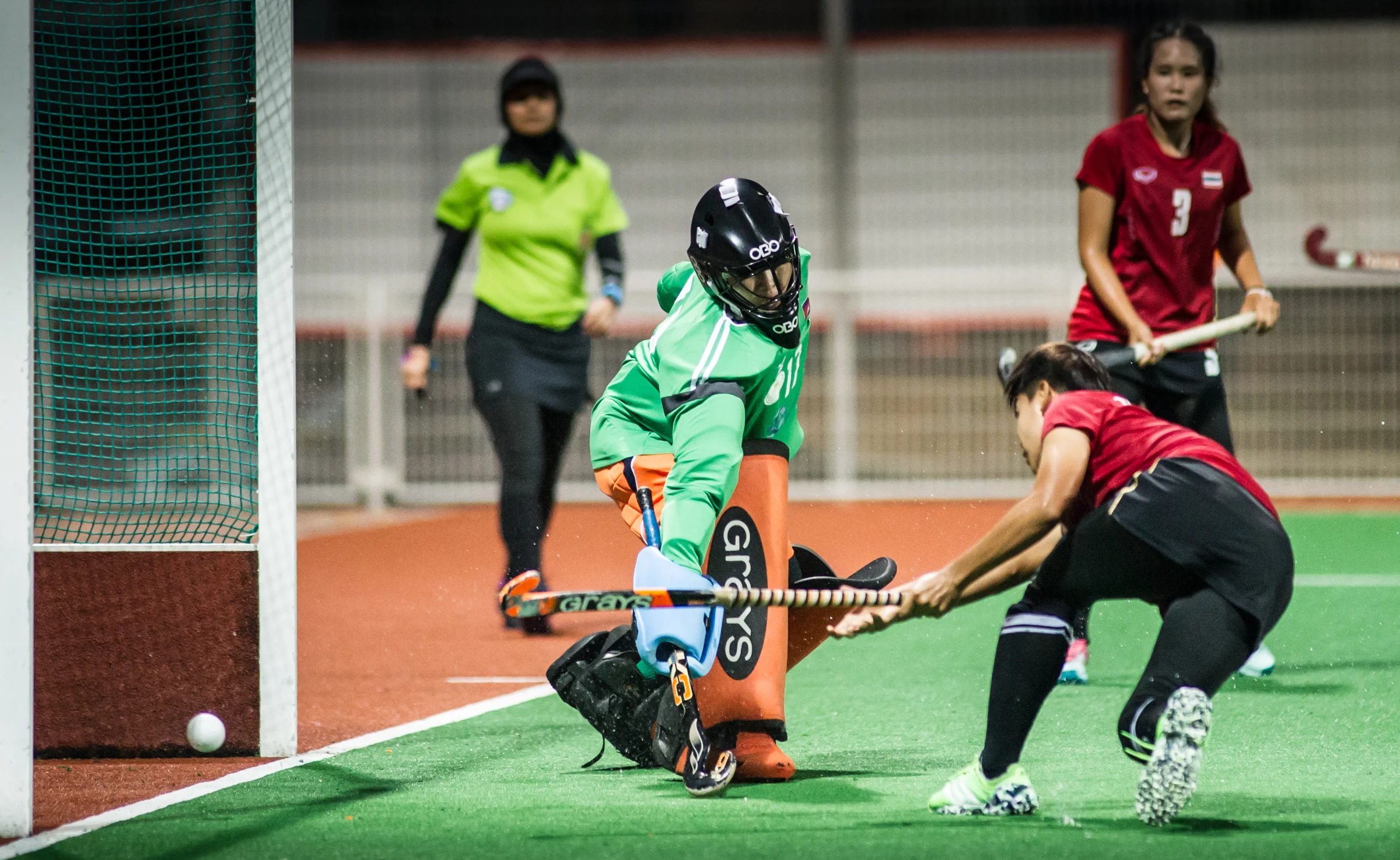 A Thai player shoots the ball past a Cambodian goal keeper during a World Hockey League match at the Sengkang Sports Complex.