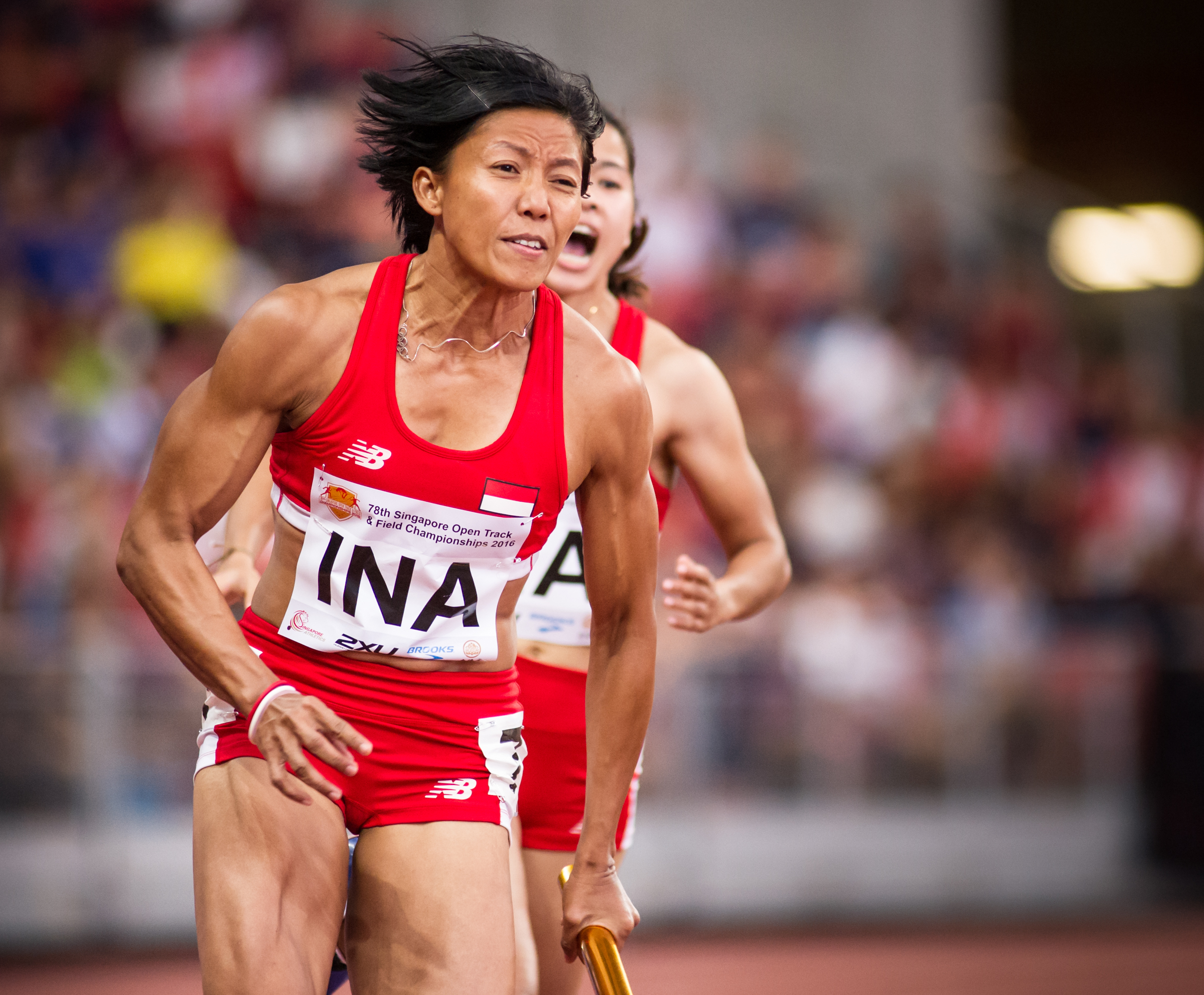 An Indonesian runner prepares to accelerate after receiving the baton in the 4 x 400 relay finals during the Singapore Open Track and Field Championships held at the Singapore Sports Hub.