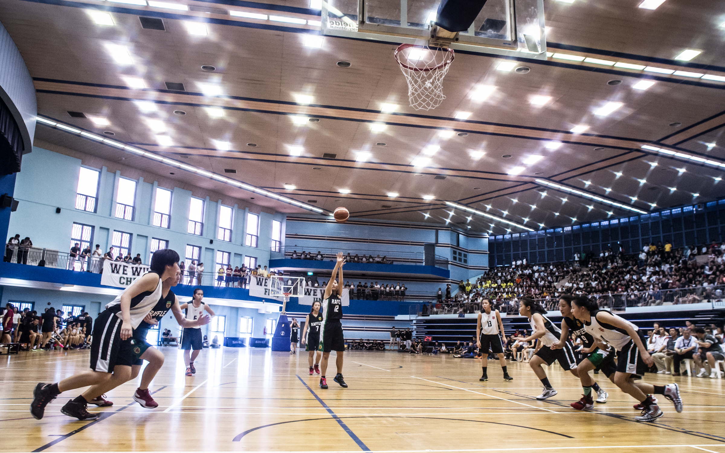 Basketball players rush forward during a free throw at a National Schools match at the Jurong East Sports Complex.