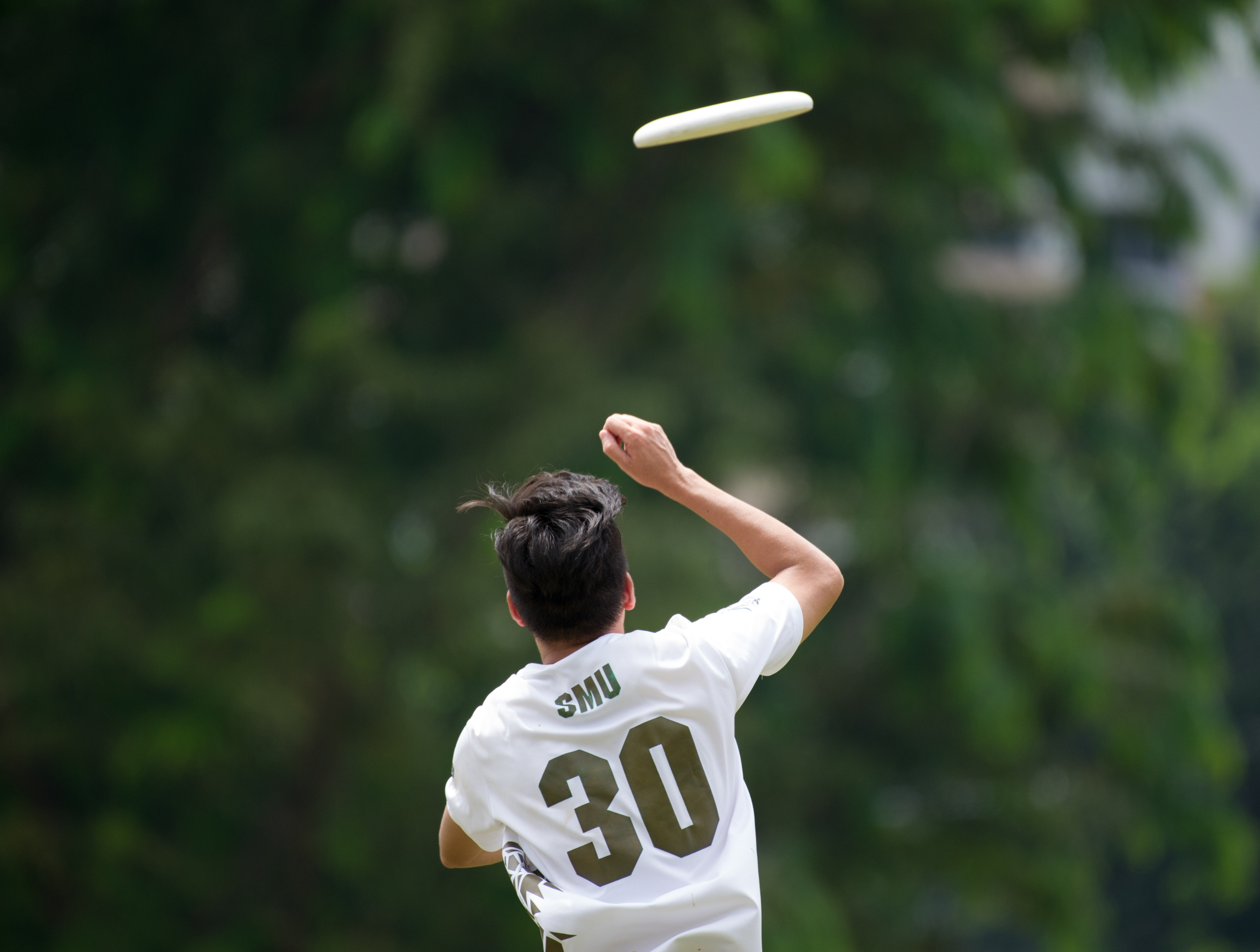 A player jumps to receive the frisbee during a friendly at Ang Mo Kio Central.