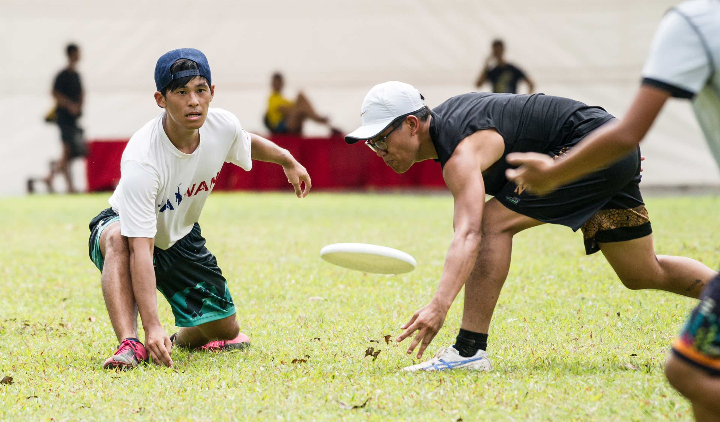 A player passes a frisbee past an opponent during a friendly at Ang Mo Kio Central.