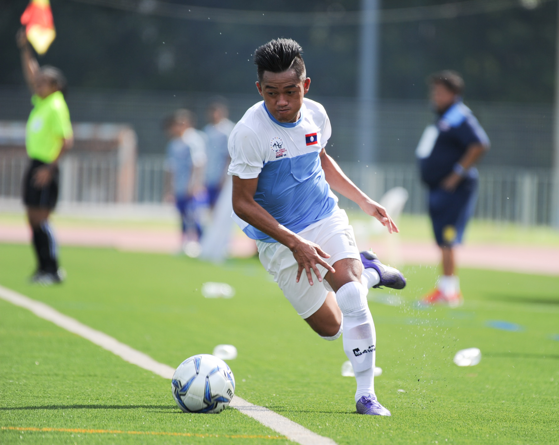 A Laotian player keeps the ball in play during the soccer competition of the ASEAN University Games at the Nanyang Technological University.