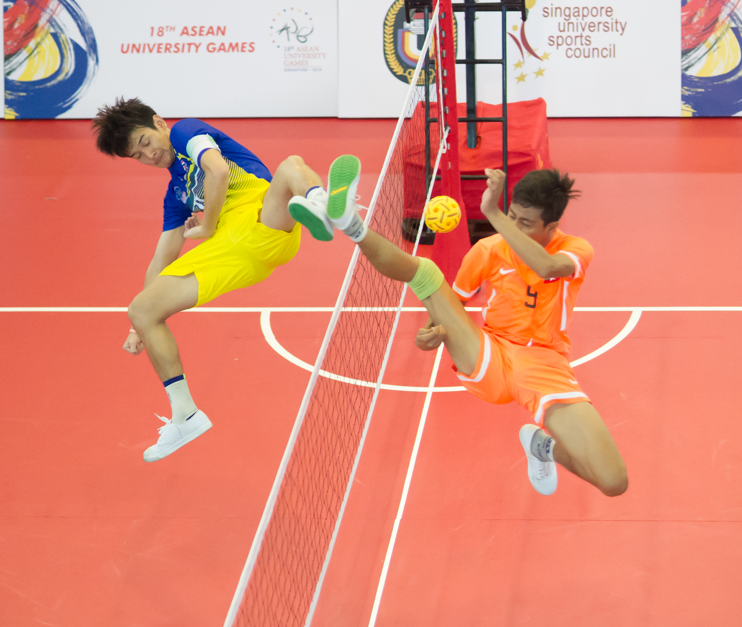A Thai and Myanmar player in action during the sepak takraw competition of the ASEAN University Games at the Bedok Sports Hall.