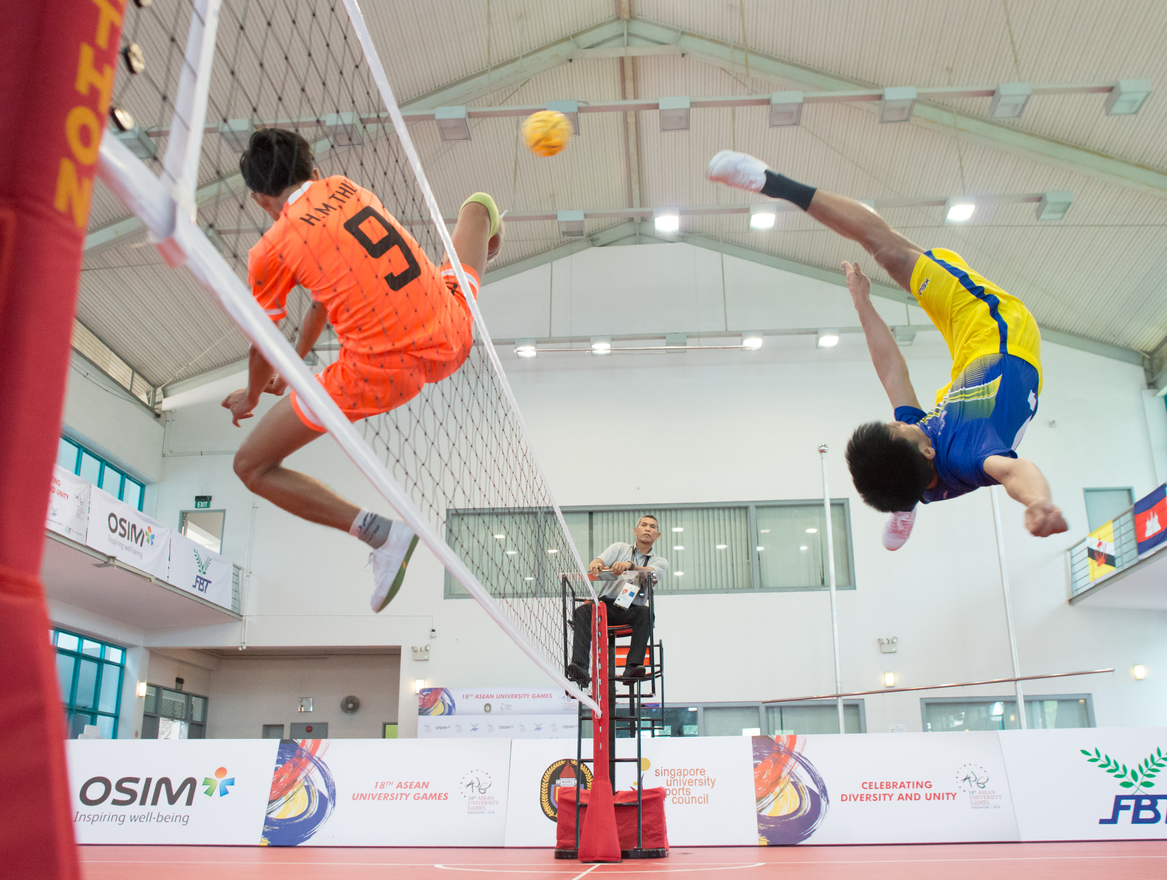 A Thai and Myanmar player in action during the sepak takraw competition of the ASEAN University Games at the Bedok Sports Hall.