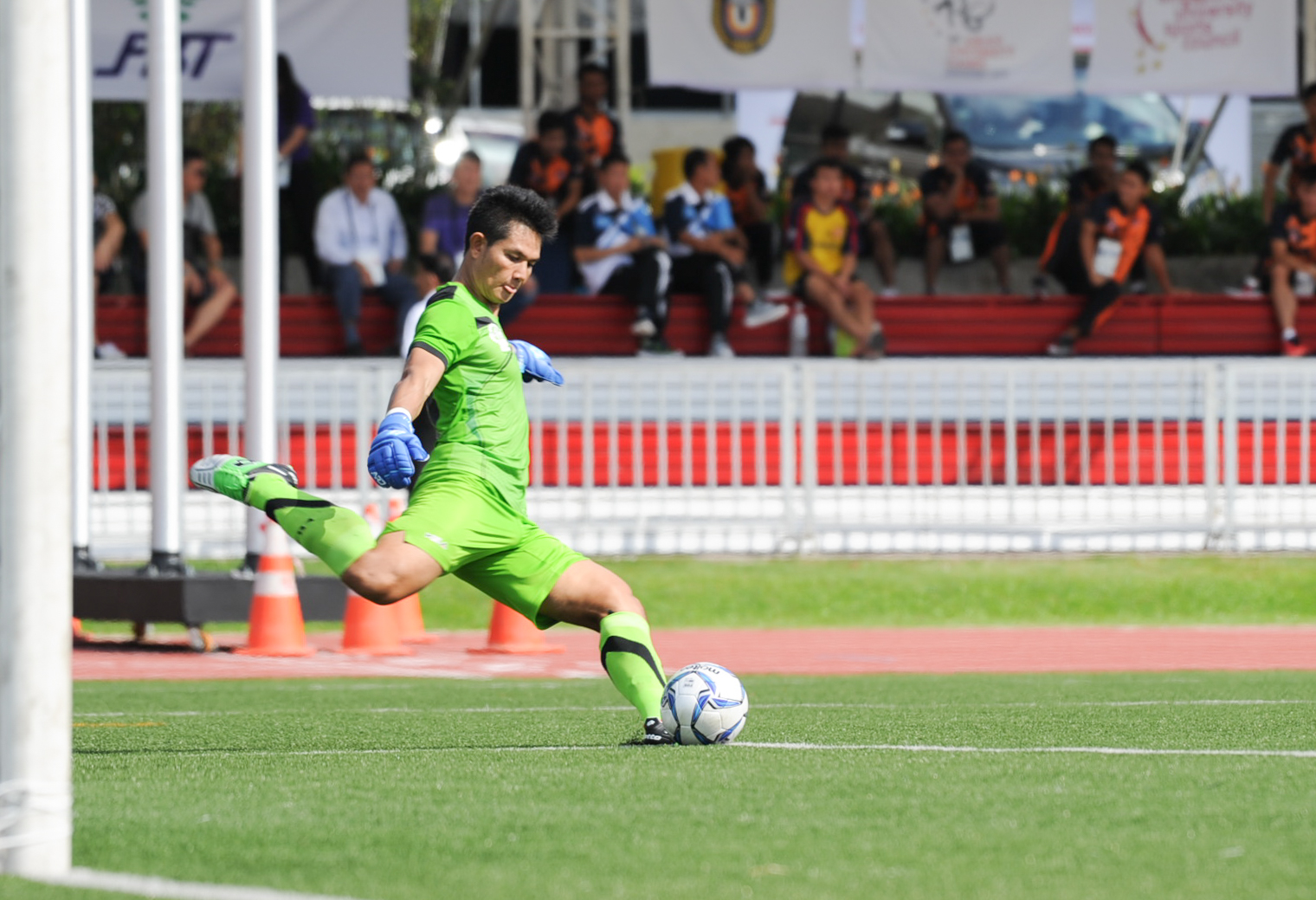 The Laotian goal keeper kicks the ball during the soccer competition of the ASEAN University Games at the Nanyang Technological University.