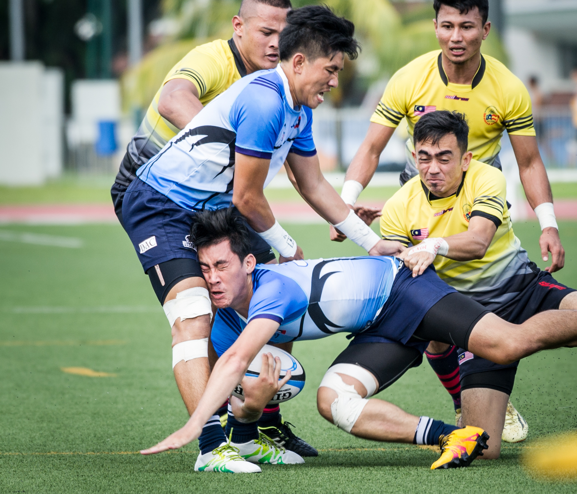 A Laotian player is tackled during the rugby competition of the ASEAN University Games at the Nanyang Technological University.