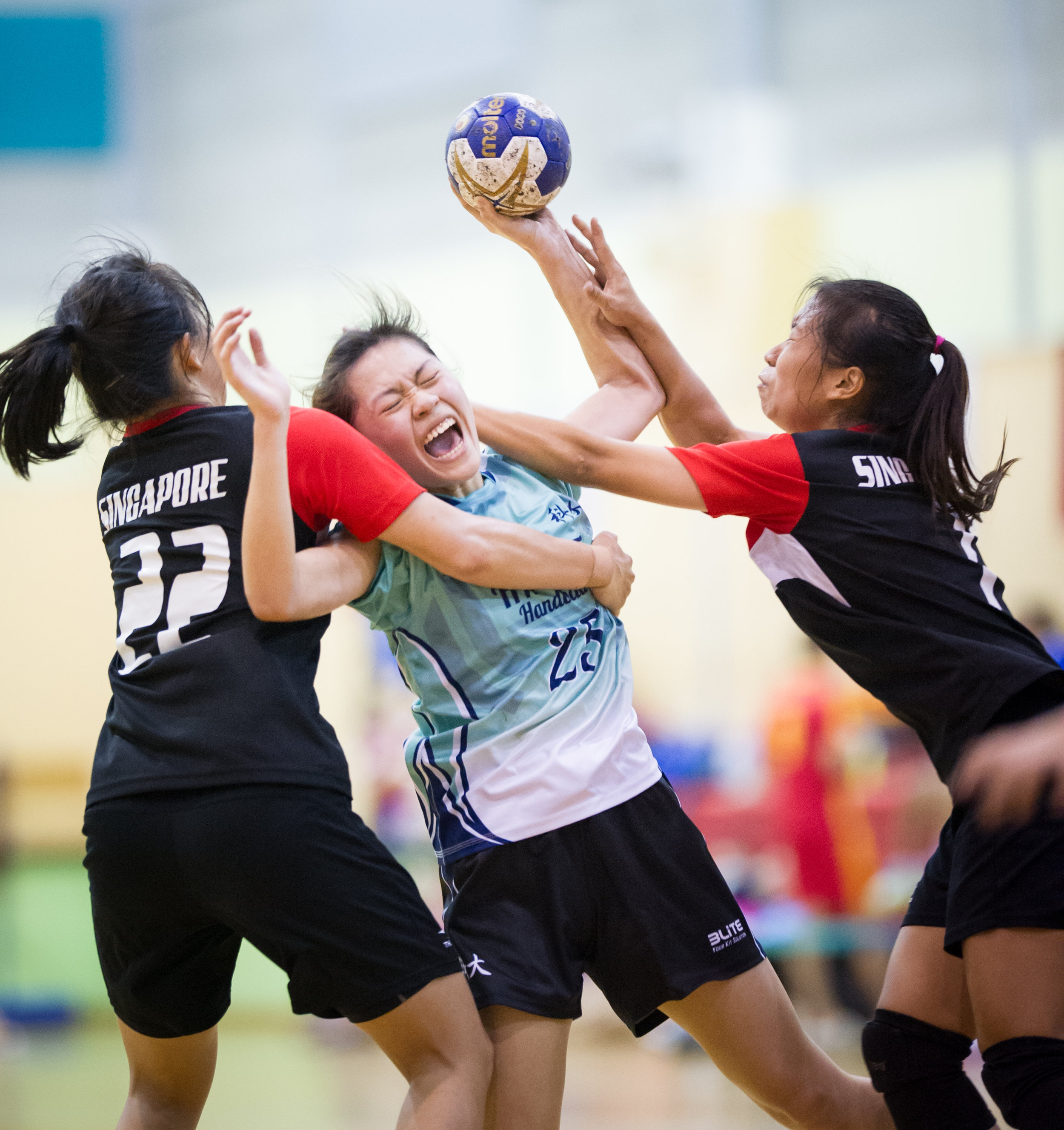 Singapore players block a Hong Kong player during an International hand ball match at the Sengkang Sports Complex.