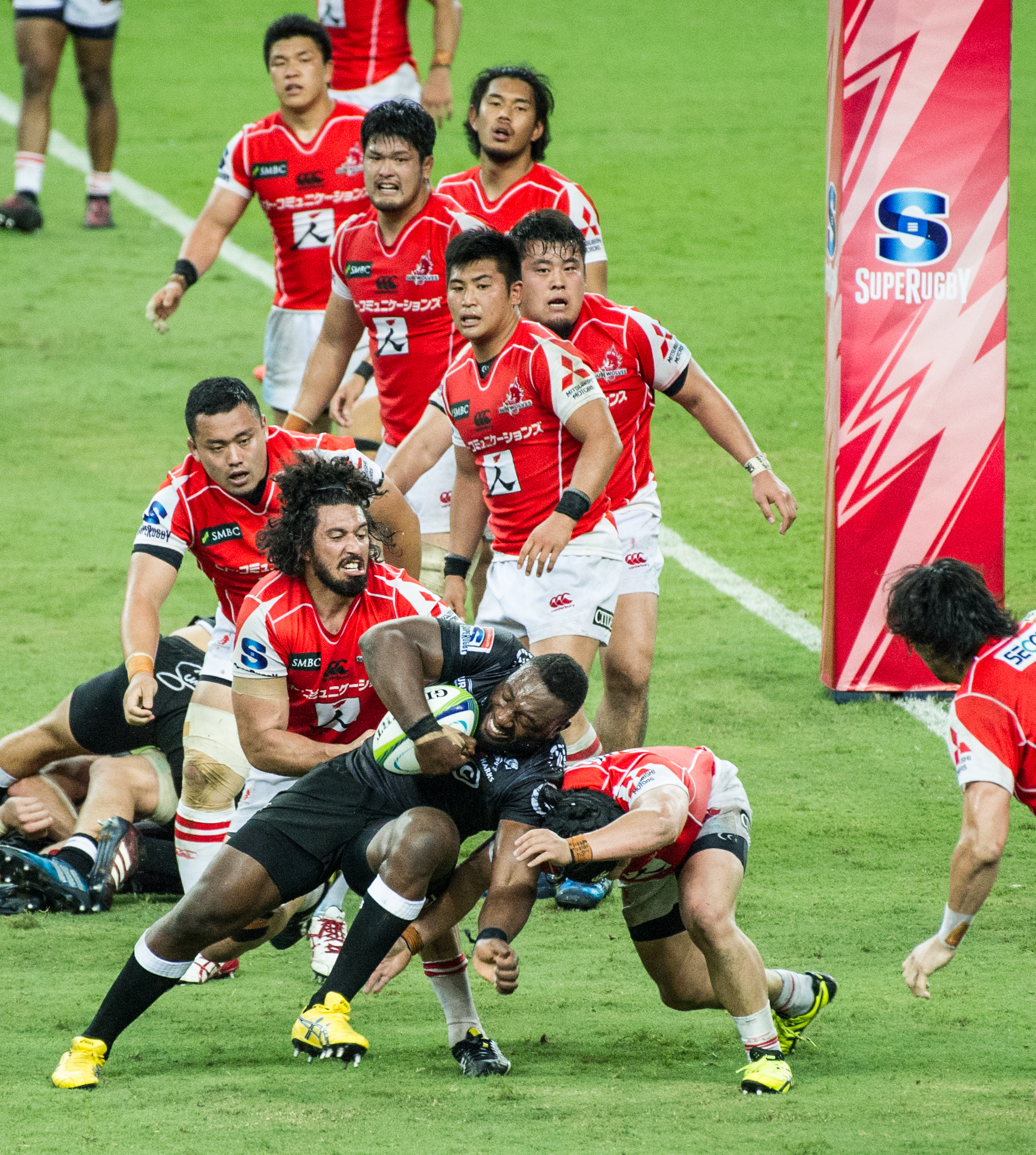 A South African player charges past a pack of Japanese players during a Super Rugby match at the Singapore Sports Hub.