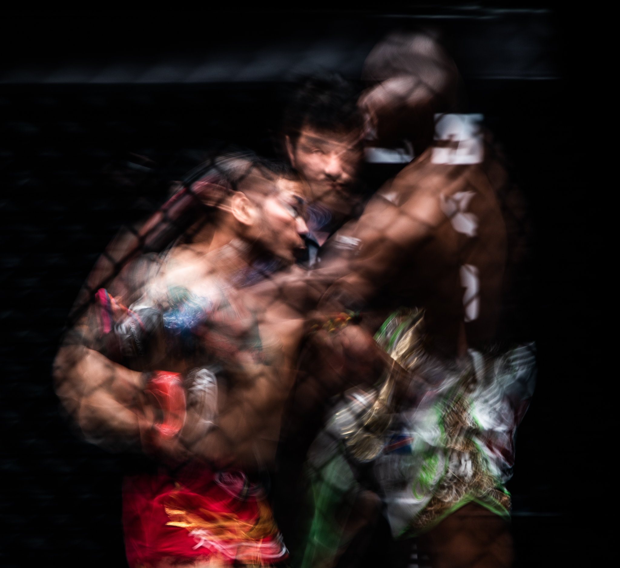 Thai and Congolese kickboxers exchange blows as the referee watches on during a One Championship World Title match at the Singapore Indoor Stadium.