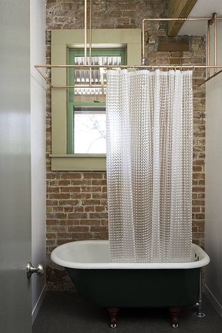 Rigid copper pipe shower curtain rod, vintage 1920’s cast-iron bath tub, residential loft, "El Picoso", San Antonio, Texas, 2008. Photo by Chris Cooper Photography