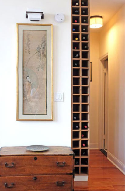 Thin floor-to-ceiling wine tower built into wasted space in a hallway.
