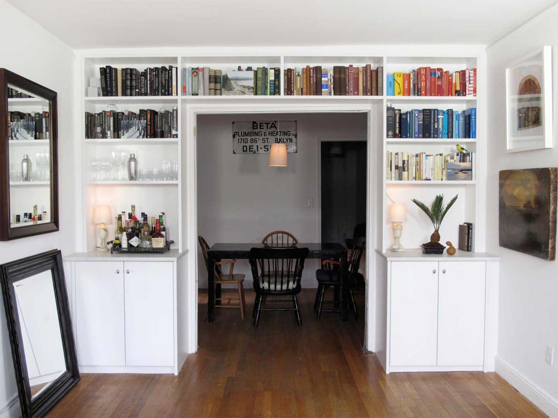 Built-in bookshelves frame the entryway to the dining room, and were incorporated seamlessly with a marble-top bar.