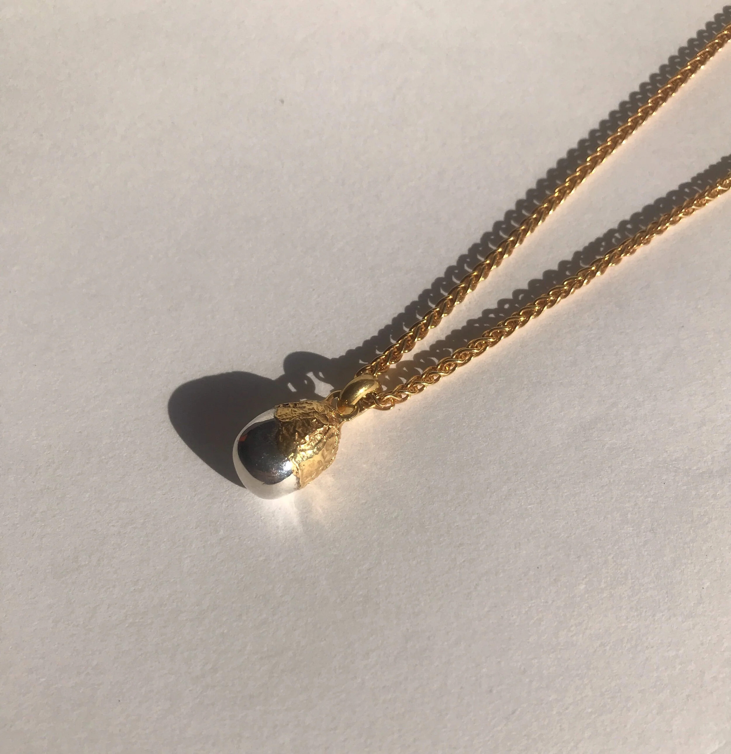 ostara egg pendant, half gold half silver, handmade jewellery, made in britain