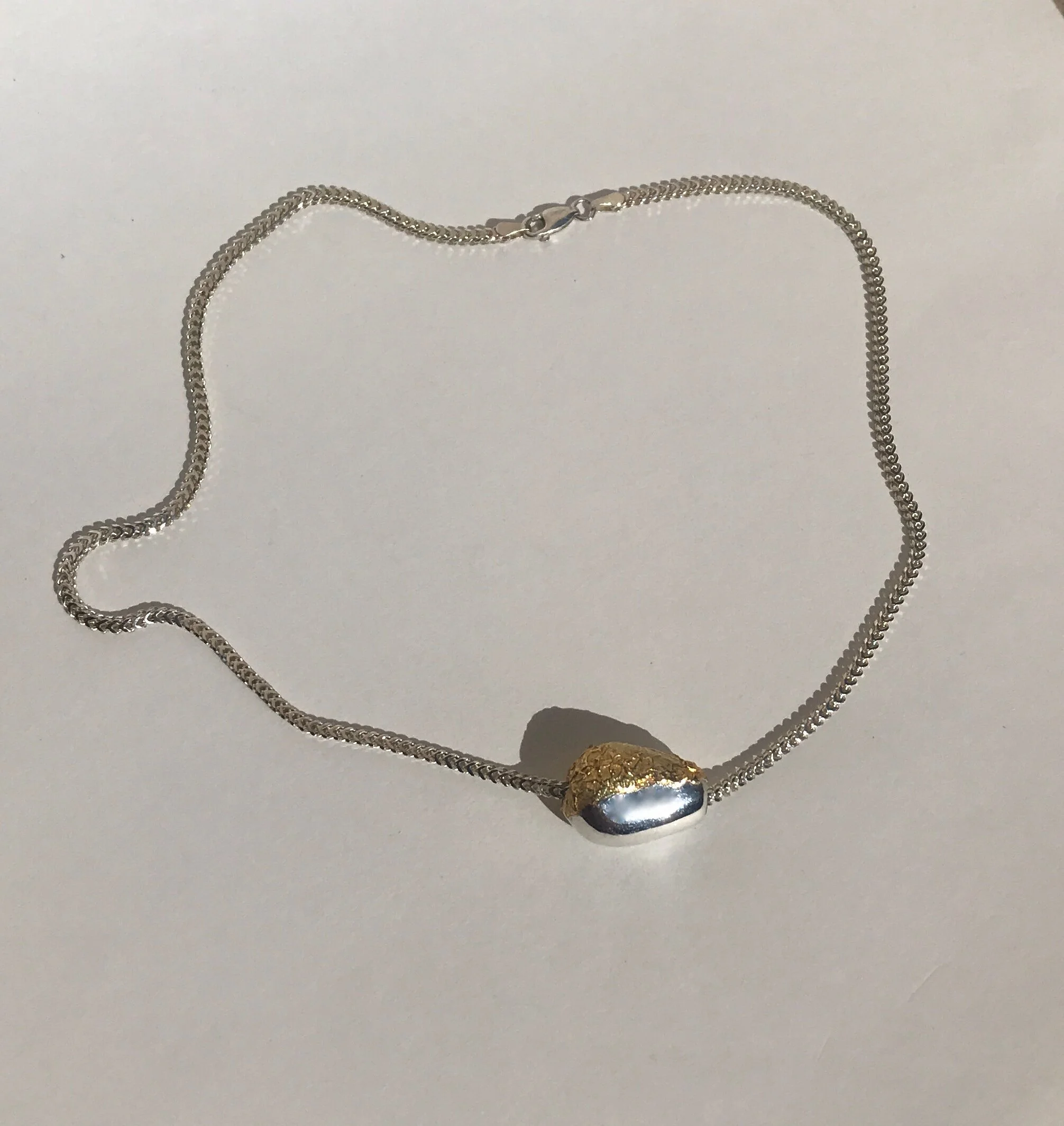 Gold and silver egg pendant, solid silver oval dipped in crushed 18 carat gold