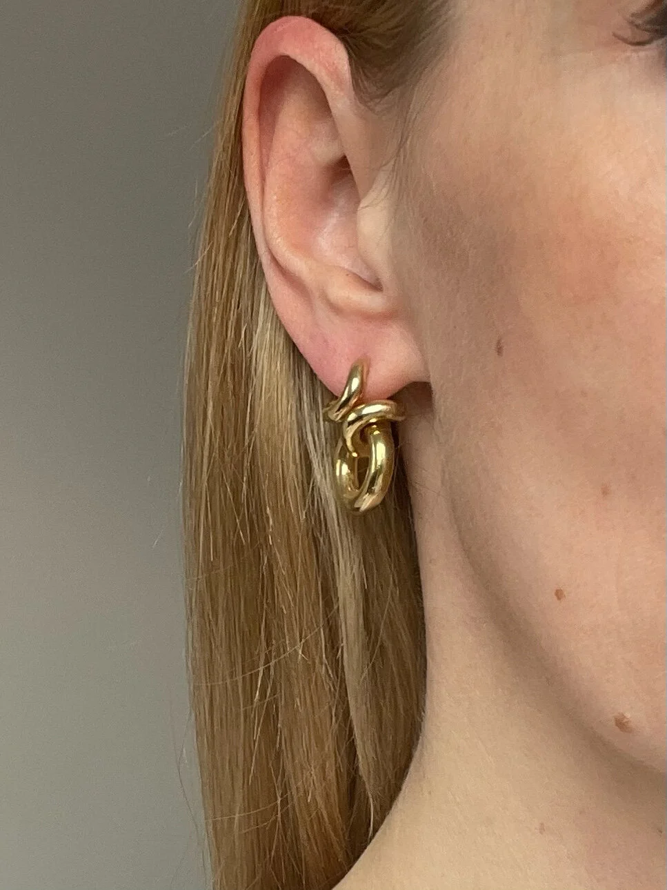 a model wearing modern gold hoop earrings