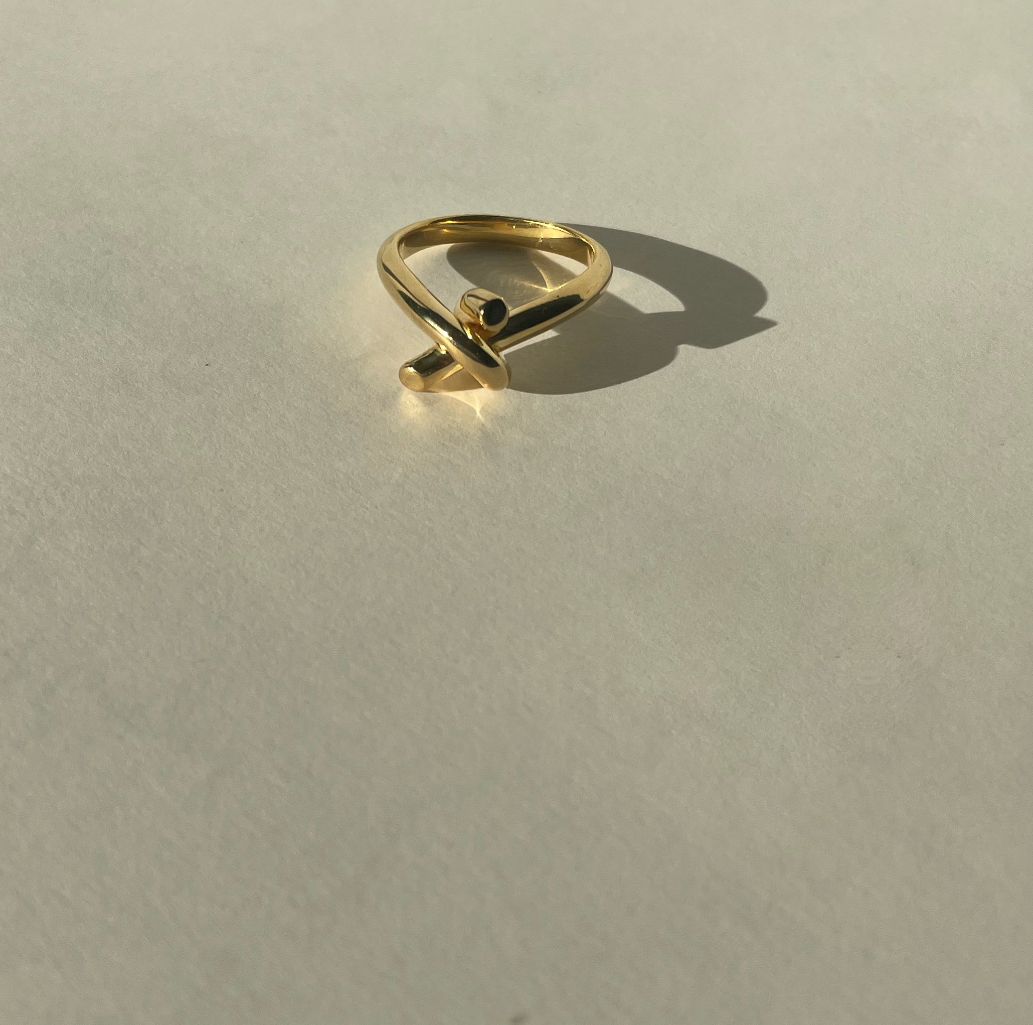 simple knotted solid gold ring, highly polished sleek and unique