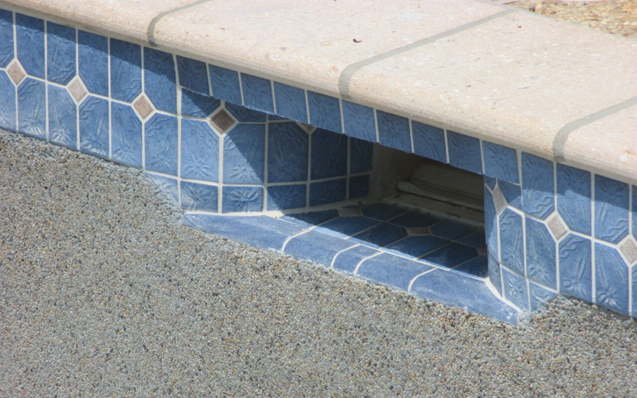  Our team pays special attention to the skimmer of the pool. Notice the trim tile hiding the coping grout across the top. Also, notice the quarter round tile used at the base of the skimmer along with the transition tile from the waterline down to th