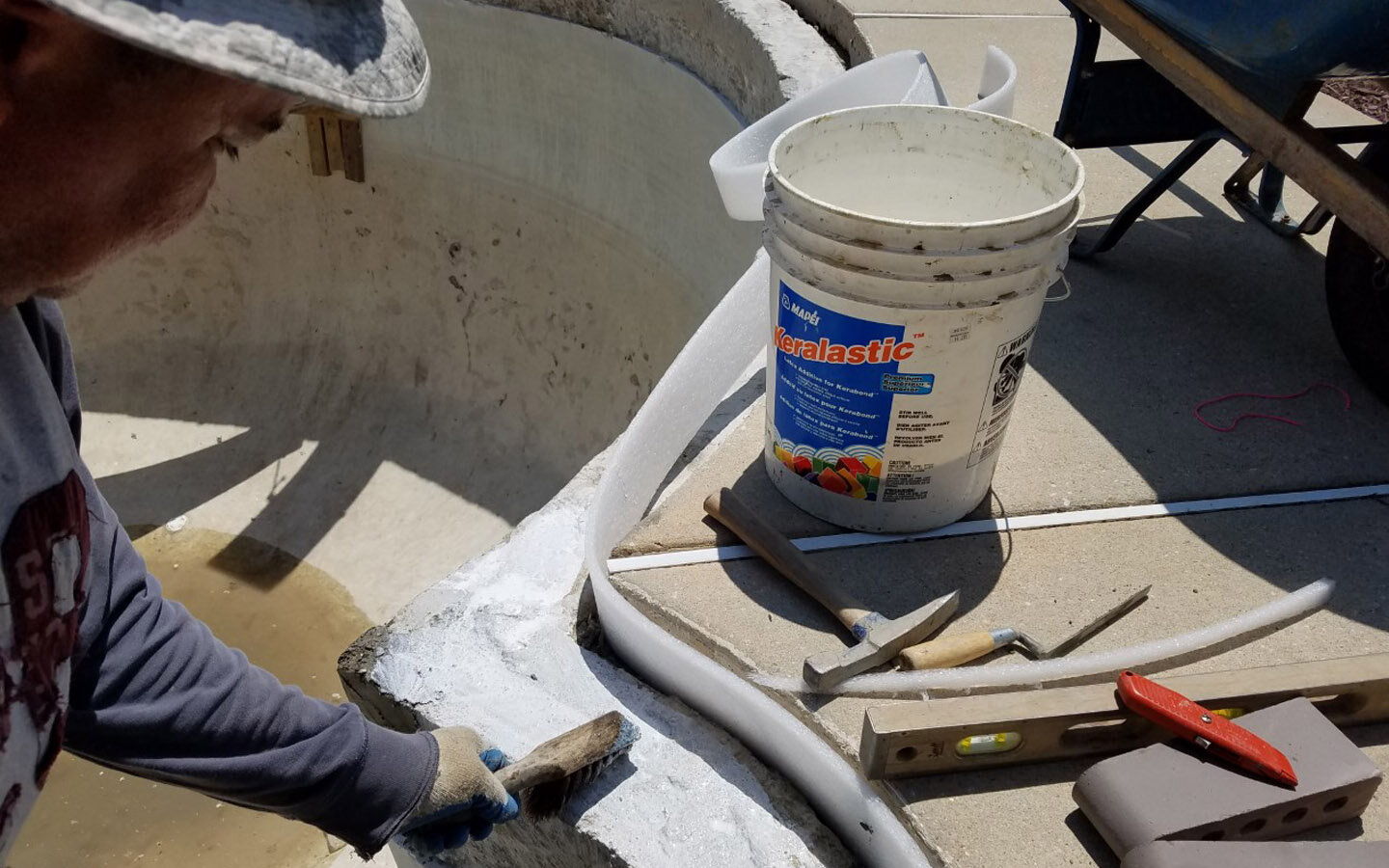  One of the keys to coping installation is to prepare the bond beam surface properly. Here you see an acrylic bonding agent being applied that "glues" the mortar bed to the beam. This process dramatically improves the life of the coping installation.