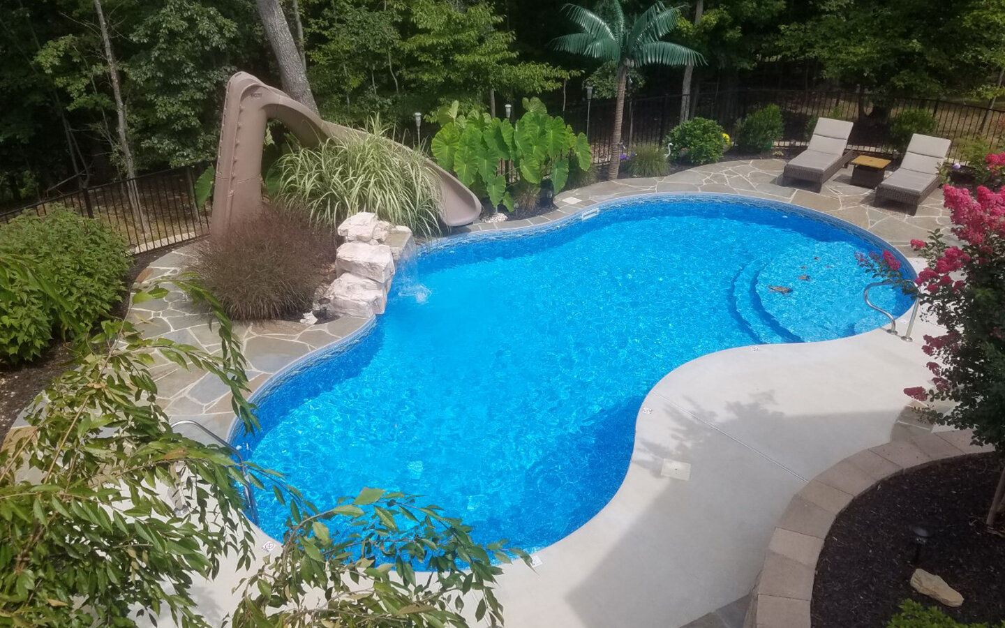  A freeform vinyl liner swimming pool and notice the  natural flagstone accents within the patio. 