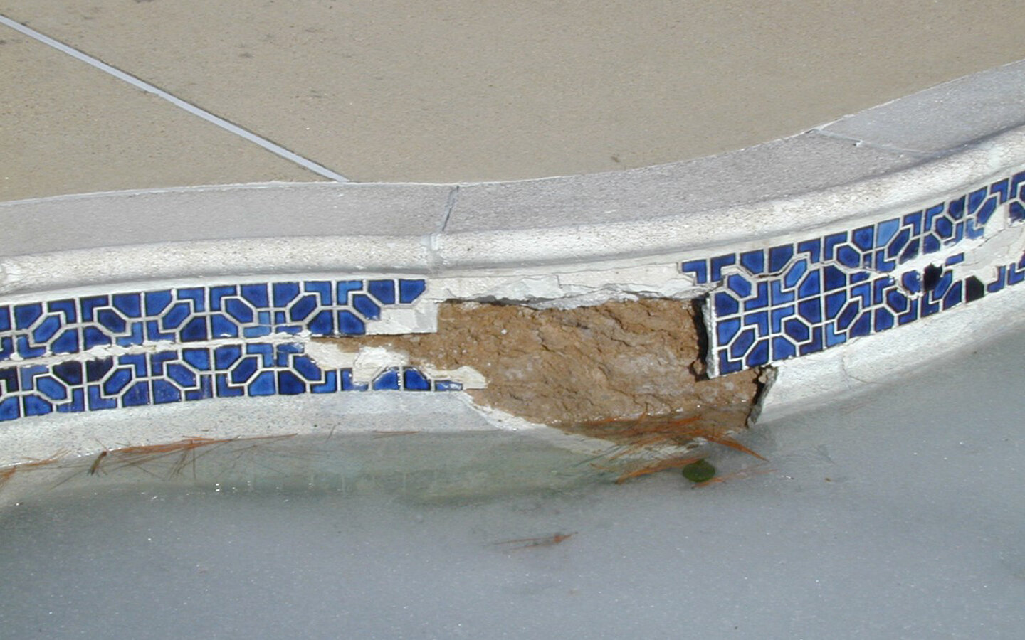 The use of epoxy repair is evident in this waterline tile failure. It’s the white stuff midway down the tile running horizontally. Use of this is a sign that the tile failed several seasons back and was temporarily repaired with this product. It did