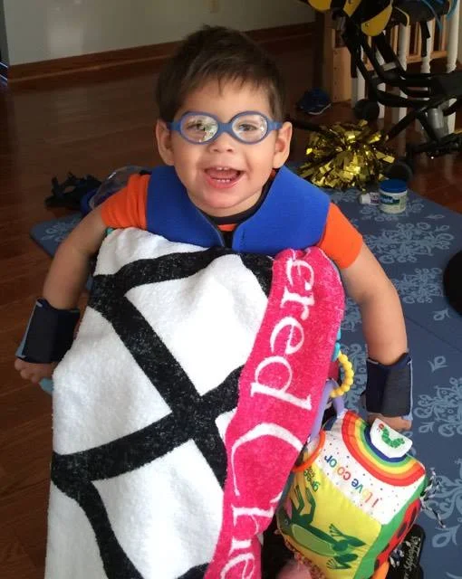 Max at 22 months in his stander with his splints and benik vest on.