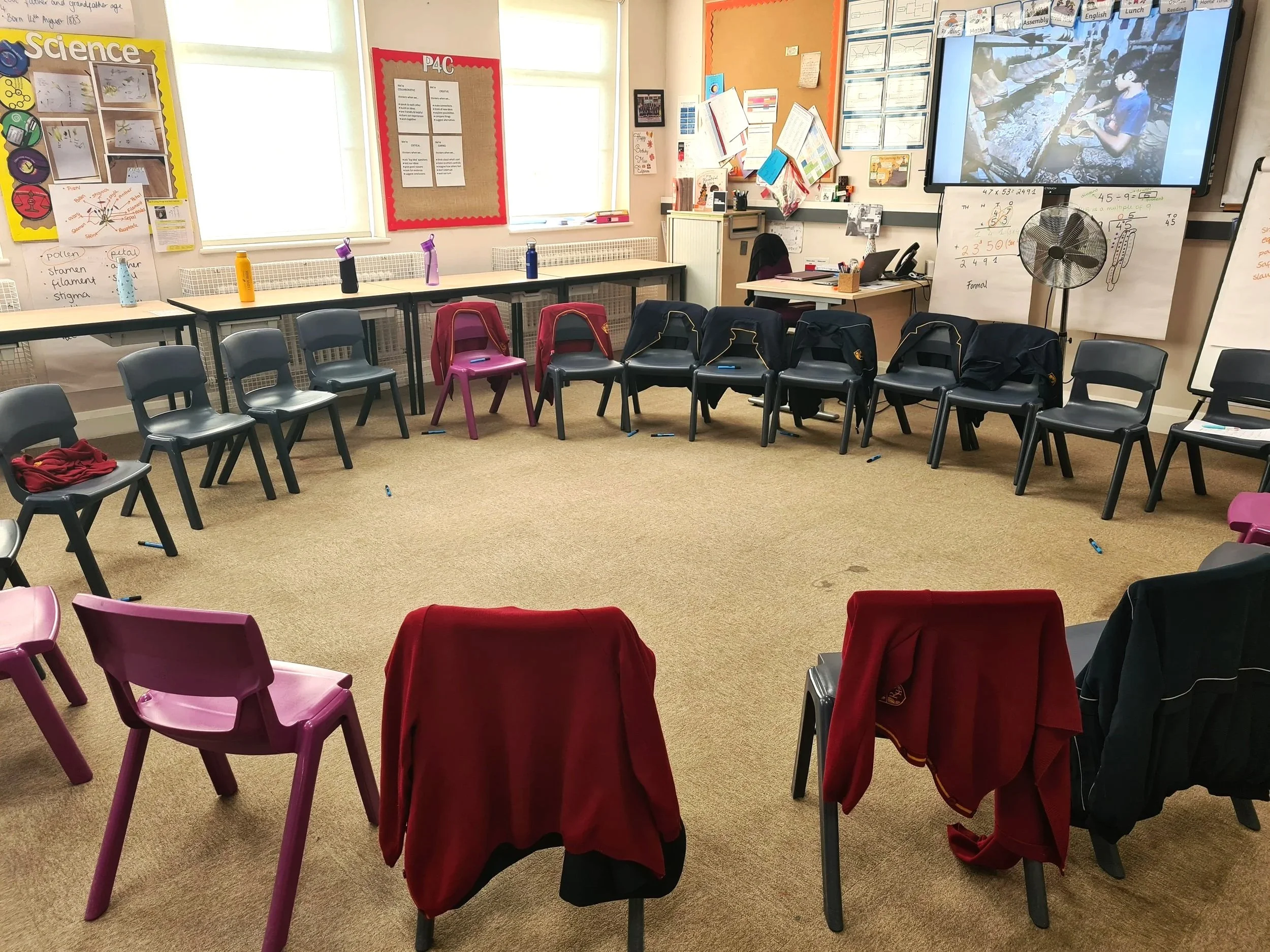 A classroom with chairs in a circle and a picture stimulus on screen