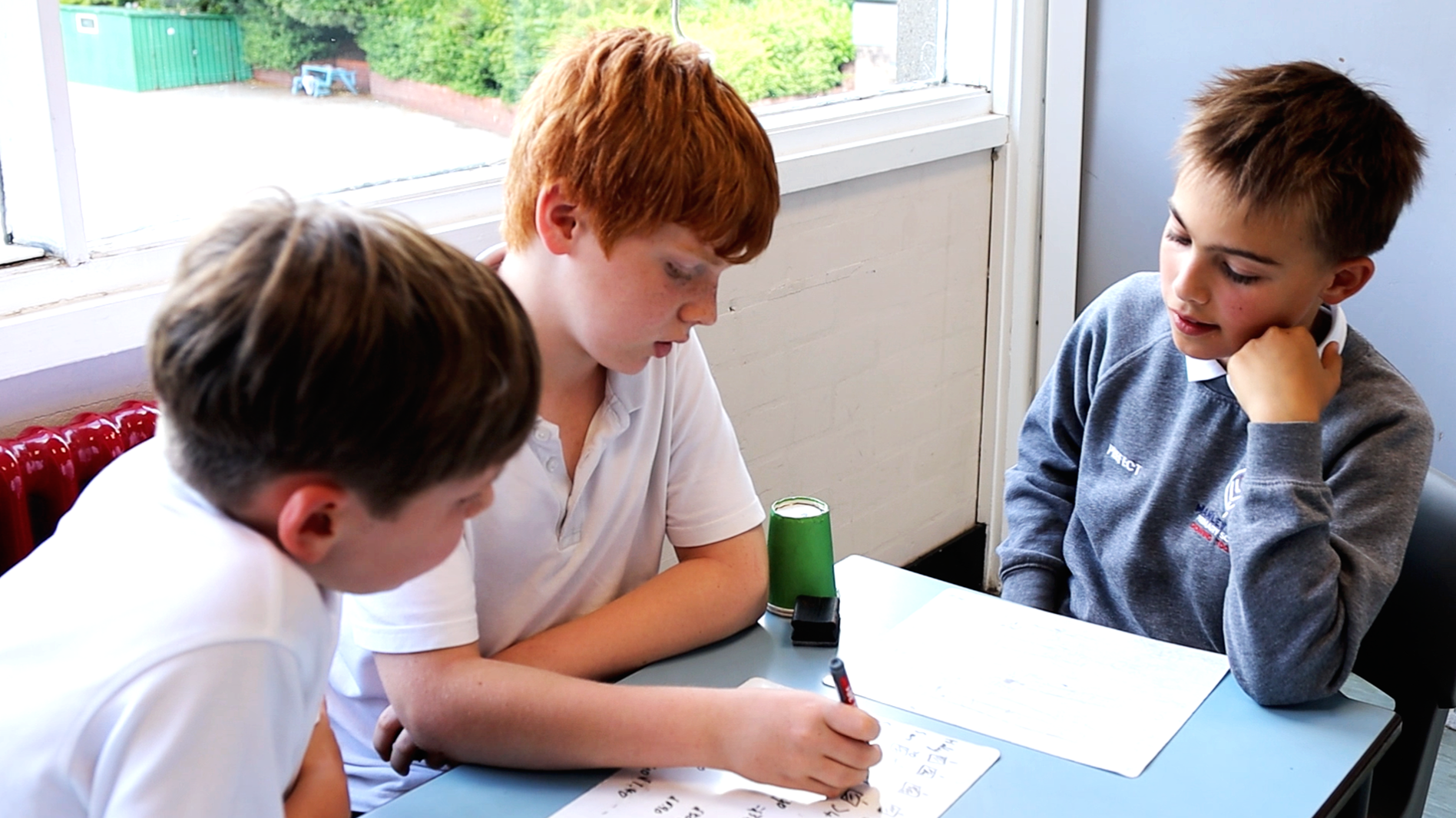 Three pupils discussing a maths problem