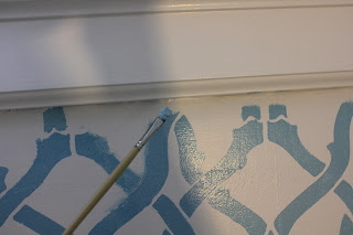 Hand-painting the stencil to meet the molding