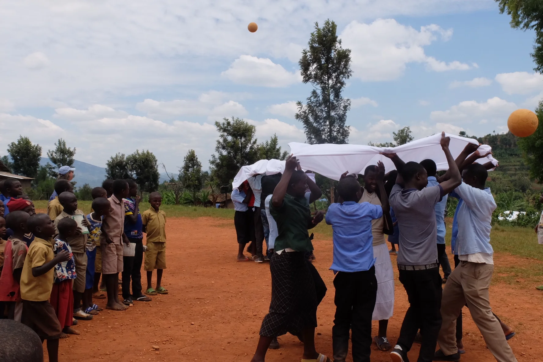 Students in Rwanda participate in behavior change focused mosquito net games at a STOMP Day Camp.