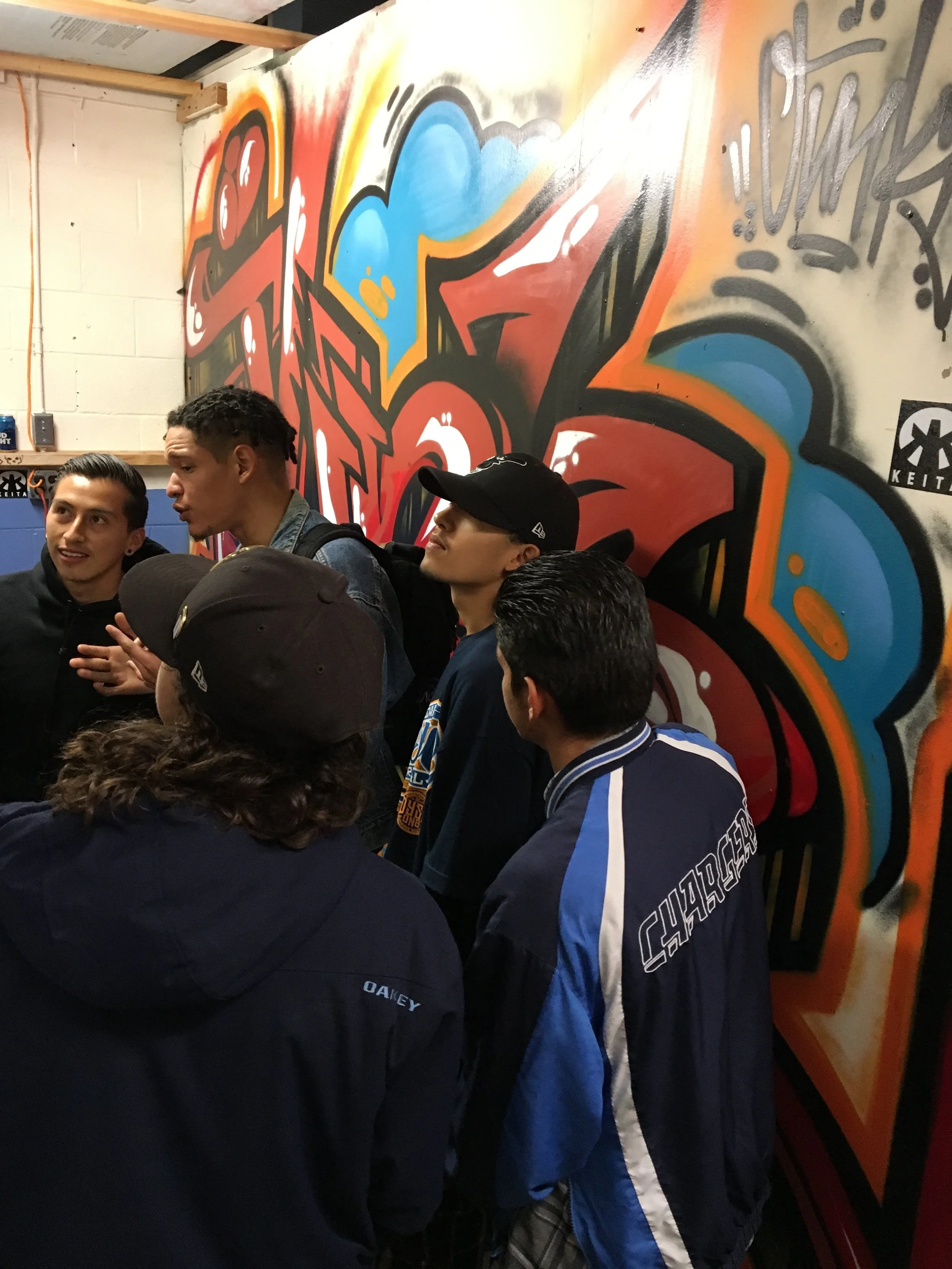 behind the people on the wall, by artist JUNK. Thanks for everything FAM