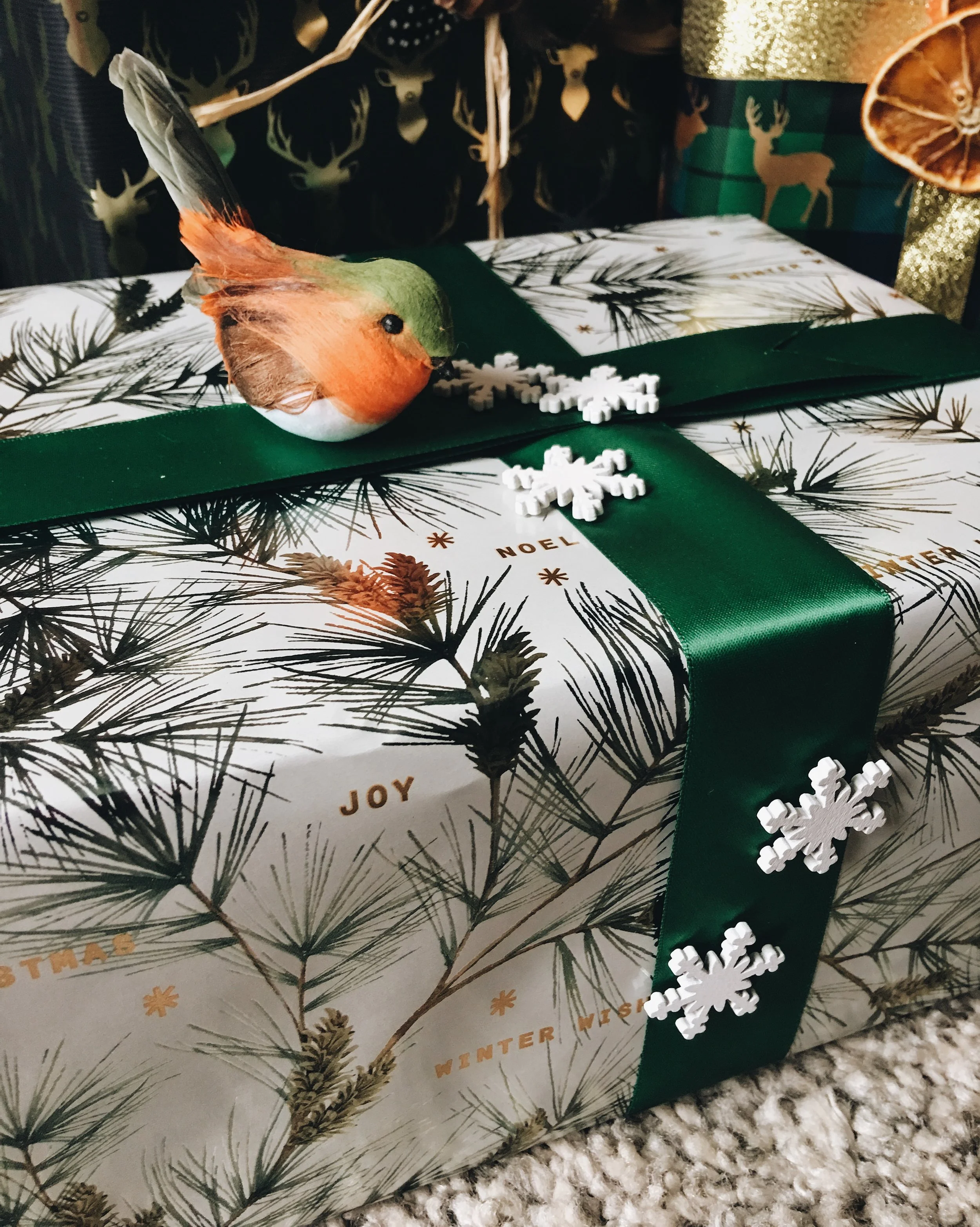 Wrapping paper by M&S. Green ribbon and red robin clip on bird by Hobbycraft. Wood snow flakes by Sainsbury's.
