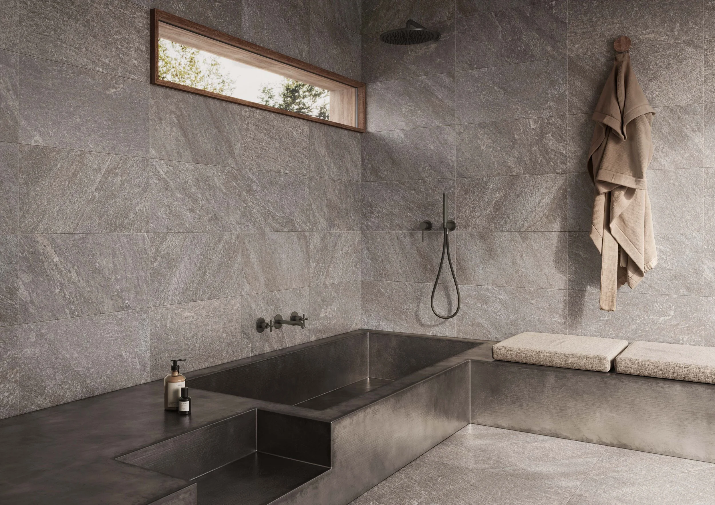 Taps and a bathing area in dulled metals work well with Petra Antracite on the floor and wall.