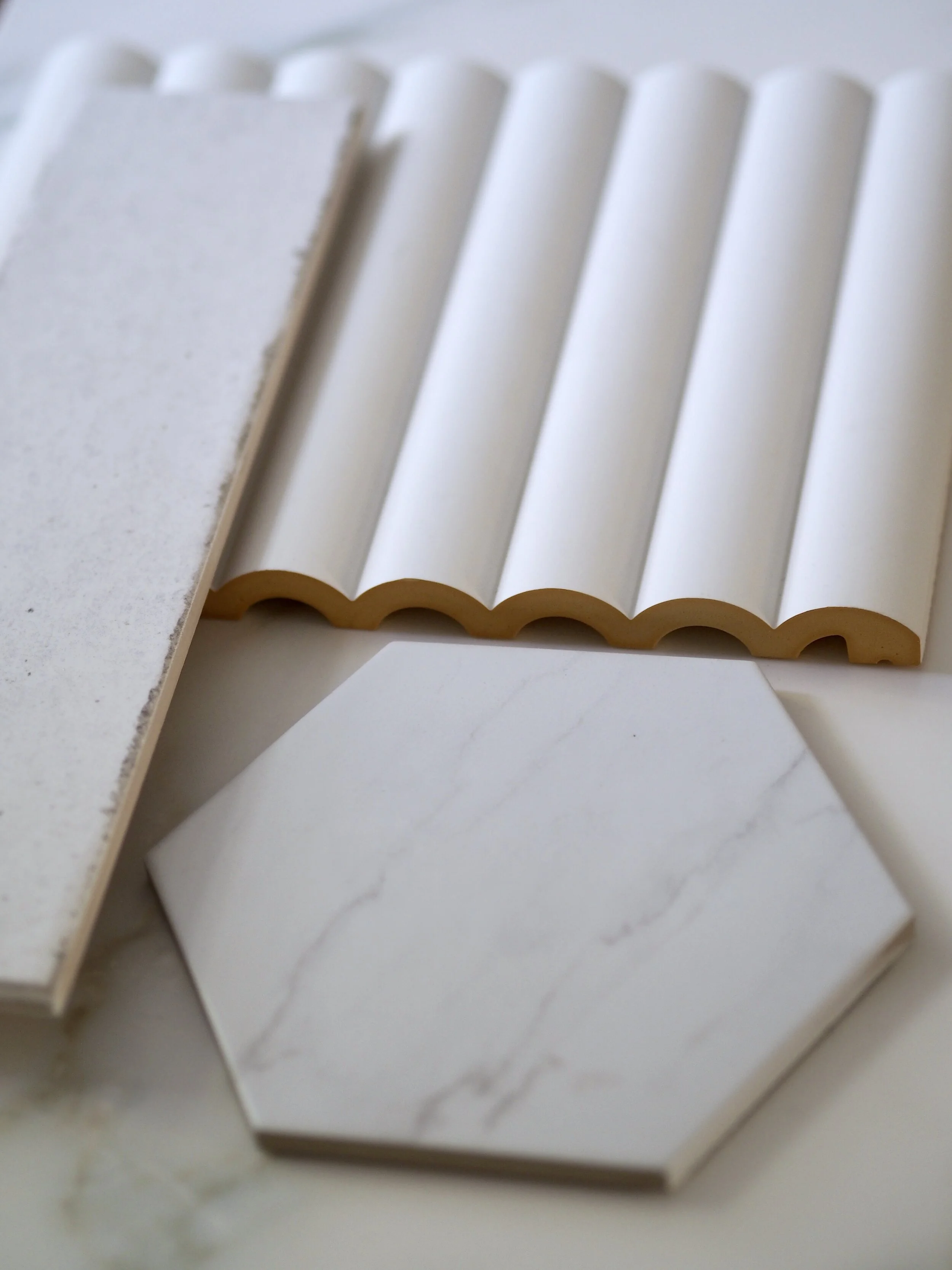 My marble hex floor tiles and aged-edged tiles from Verde Tiles. Plus, a sample of my Orac Decor wall panel.