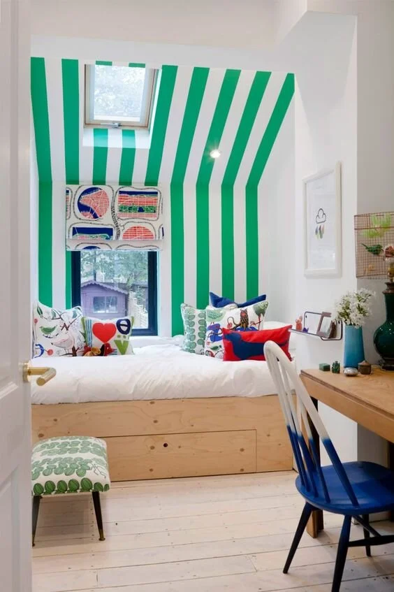Painted stripes add interest and height in this compact bedroom. Design by 2LG Studio.