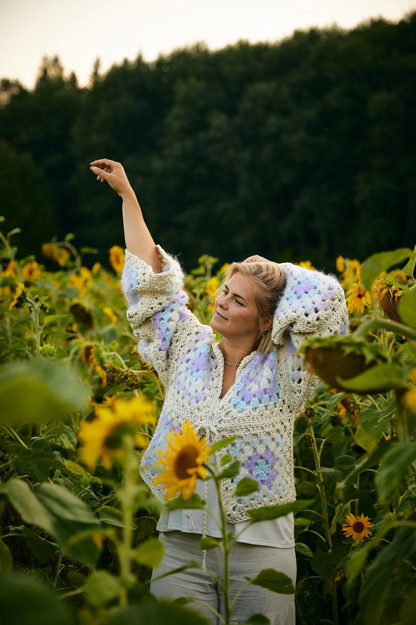 Eva Estlander standing in a sunflower field with arms raised, representing Module 2: Soma of the certification