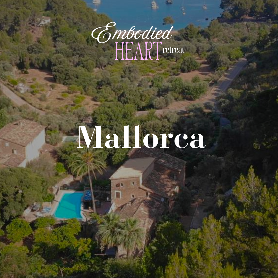 Aerial view of a lush green landscape with Mediterranean-style houses, a swimming pool, and a bay with boats in Mallorca, Spain, during daytime.