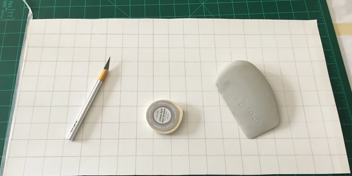 Paper, cutting mat, Xacto knife, masking tape, plastic scraper