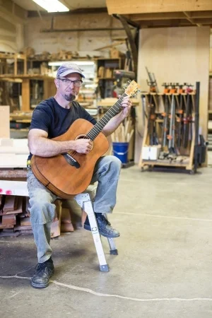 Will Nash plays one of his acoustic guitars in his workshop.