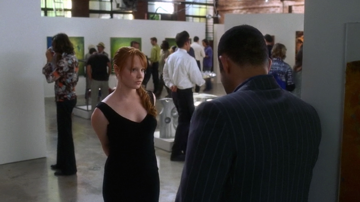 Claire during gallery scene with abstract panels in background