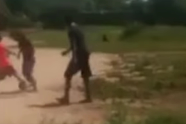 A still from the video shows the creature in the background of the children's game.