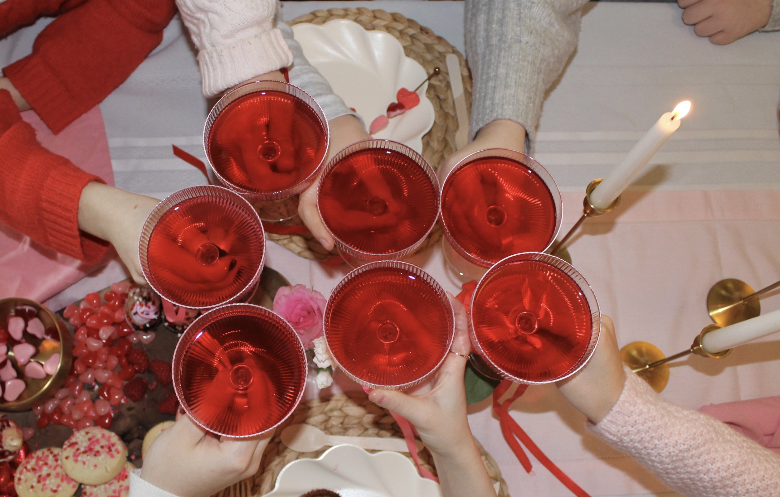 Seven glass cheers-ing over a table set with Girls' Night In box