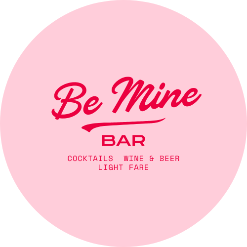 Pink circular sign with text that says "Be Mine BAR" and smaller text below that reads "Cocktails Wine & Beer Light Fare".