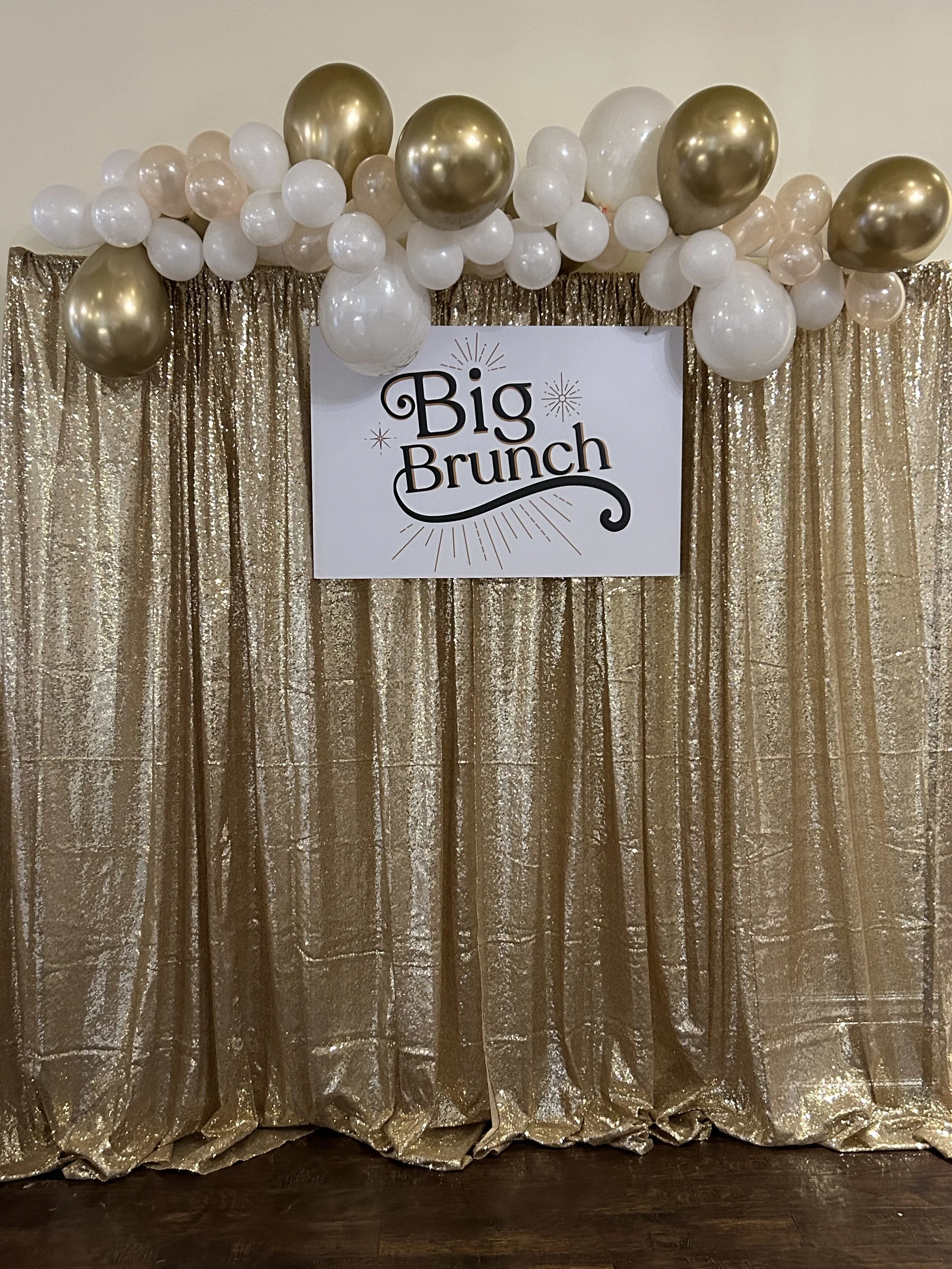 Our champagne sequin backdrop has been dressed up with balloons and a sign that reads "Big Brunch"