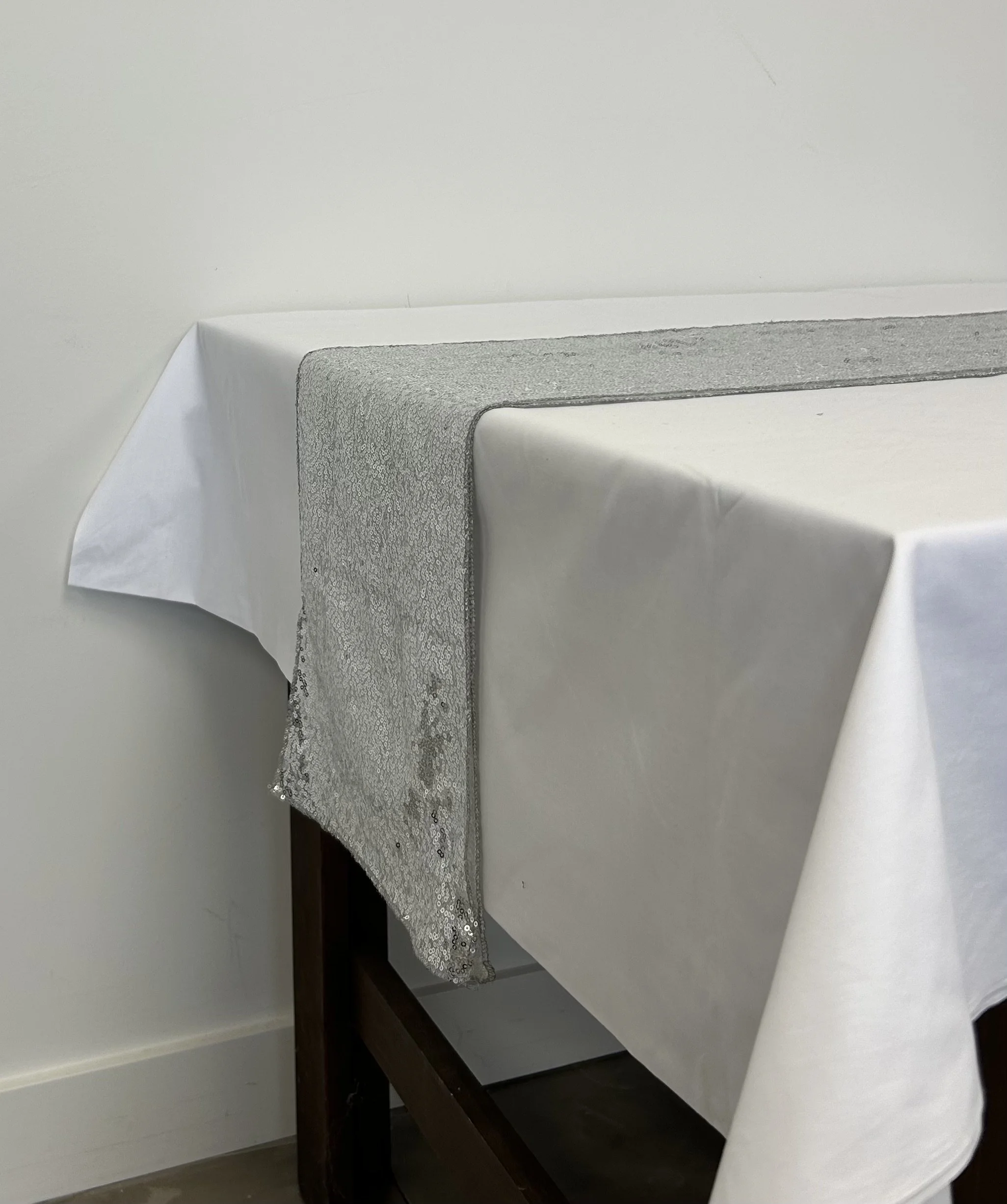 Silver sequin table runner on white table cloth for a pop of sparkle