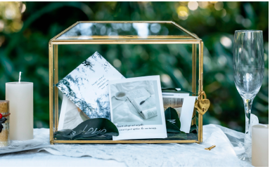 Glass box with gold frame and fixtures with cards inside