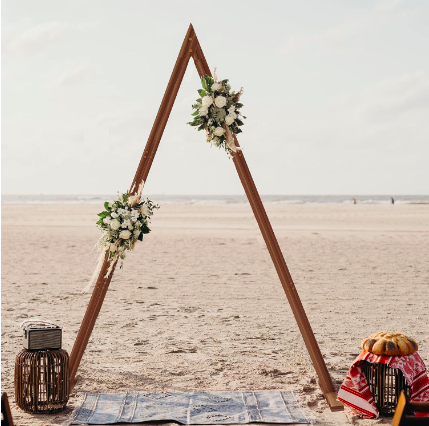 A-frame wooden wedding arch set up on beach
