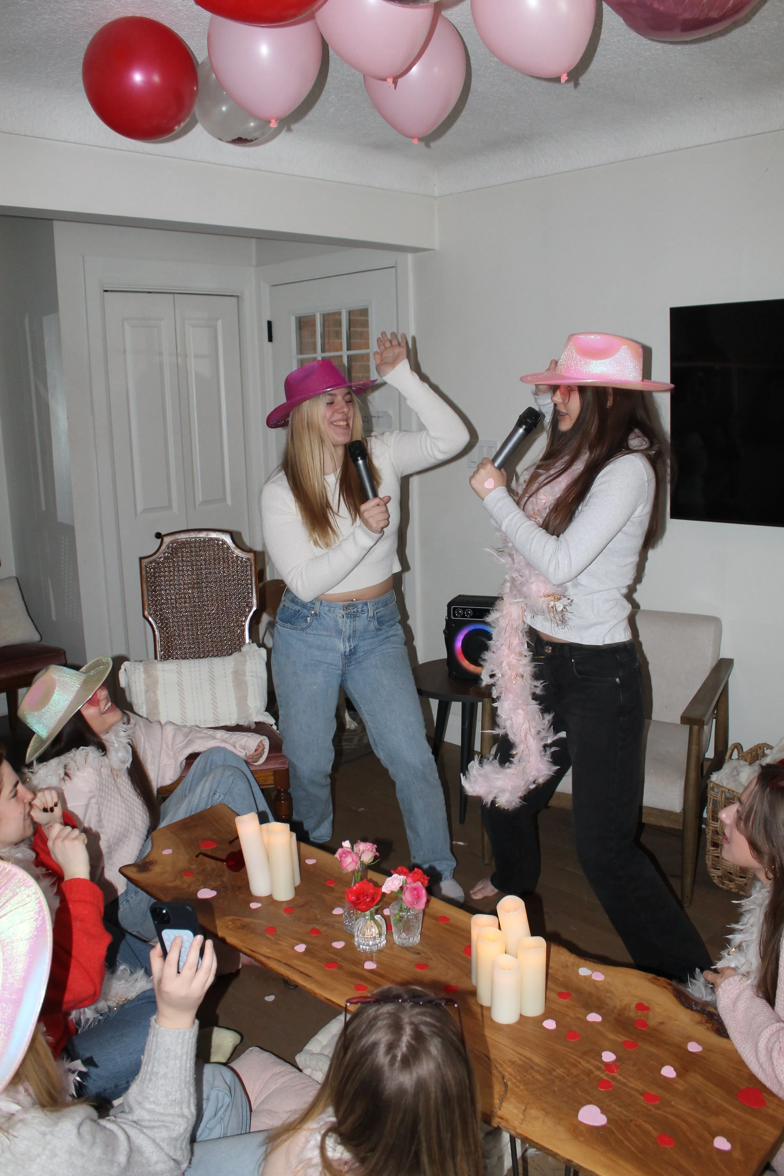 Group of friends doing karaoke with Valentine's Day decor