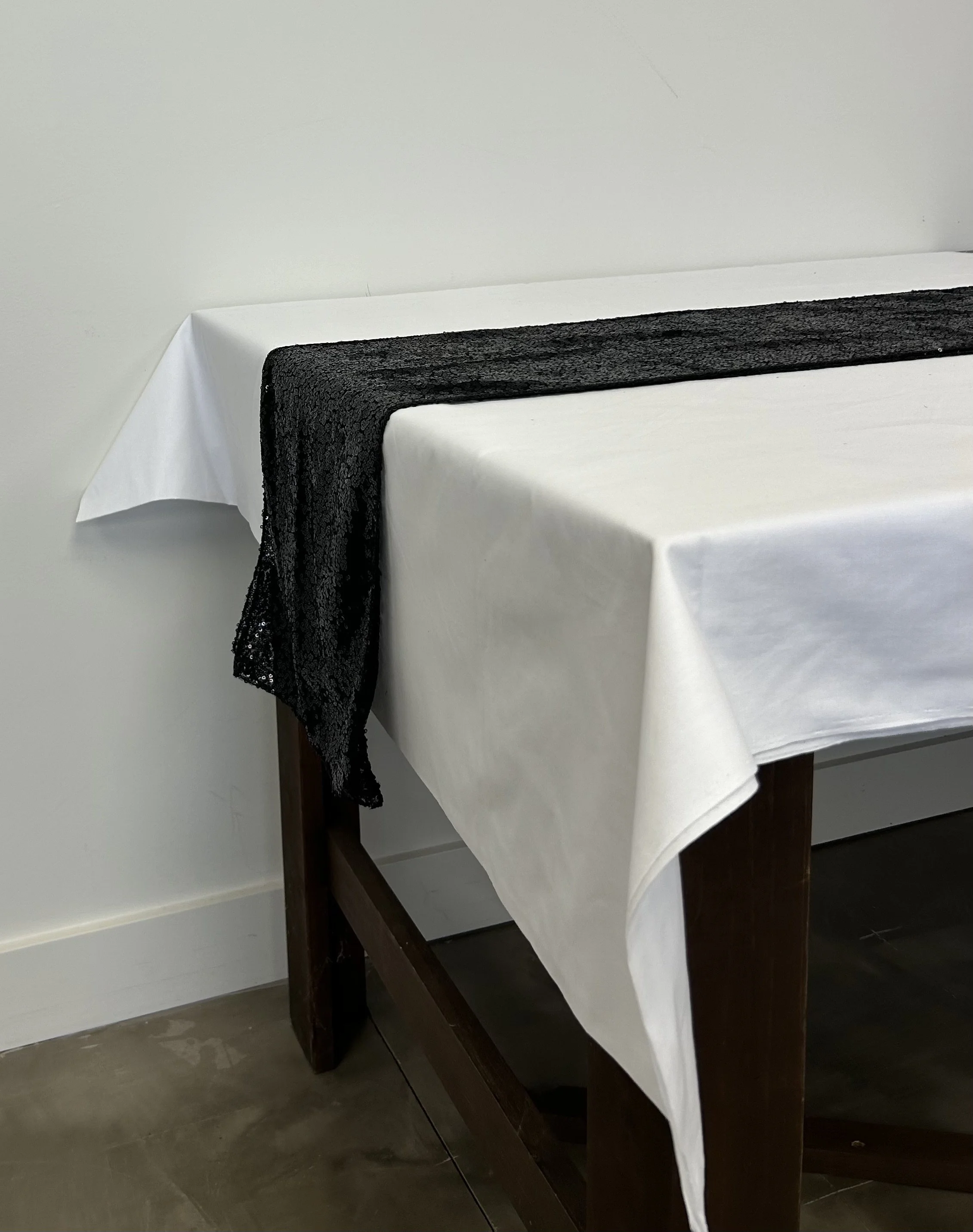 Black sequin table runner on white linen